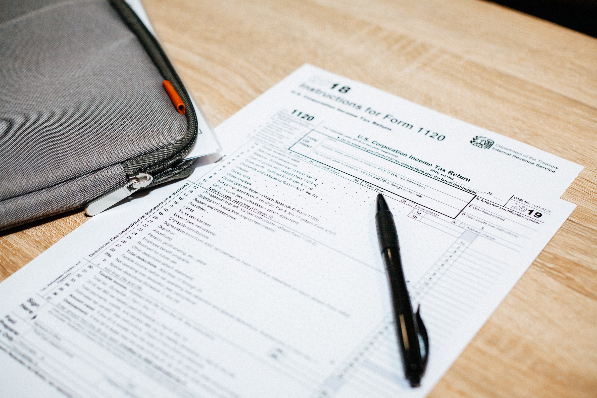 A form with a black pen, both lying on a desk